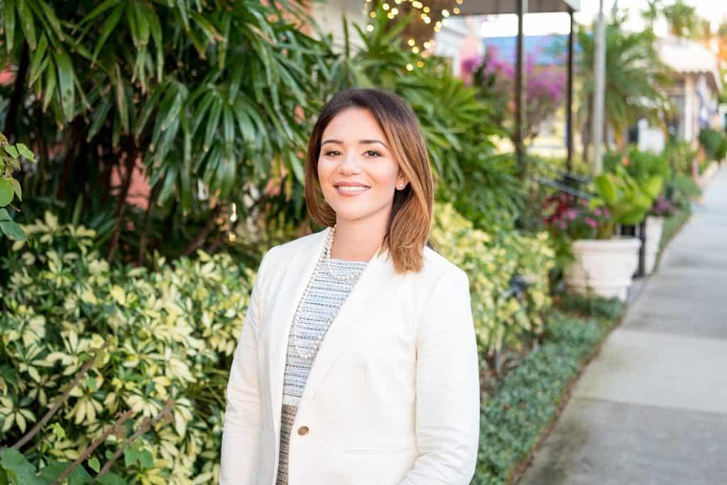 Female property manager standing outdoors in a lush summer garden
