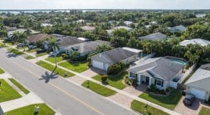 Aerial view of residential neighborhood in Palm Beach Gardens, showcasing well-maintained homes and lush landscaping, relevant to property management insights and local market trends.