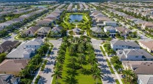 Aerial view of a well-planned residential community in Jupiter, Florida, featuring palm-lined streets, landscaped parks, and modern homes, highlighting InvestPro's property management focus.